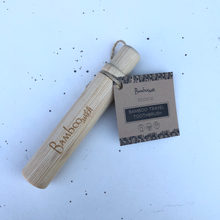 Load image into Gallery viewer, A Bamboo Travel Toothbrush shown with its paper tag. Ecofriendly and lightweight travel toothbrush by Bamboo Switch