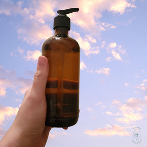 An amber glass jar with upcycled pump filled with Rustic Strength hand soap in lavender/rosemary.
