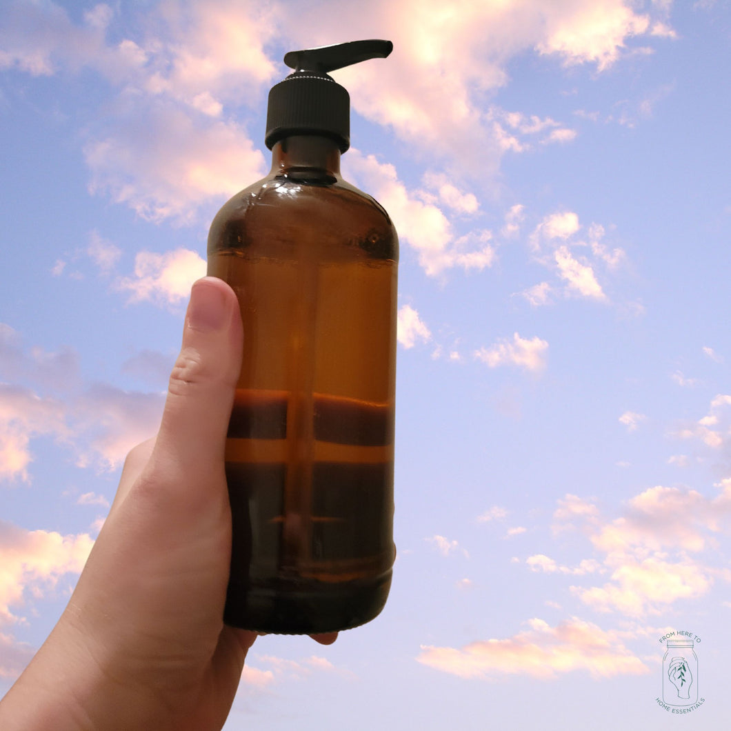 An amber glass jar with upcycled pump filled with Rustic Strength hand soap in lavender/rosemary.