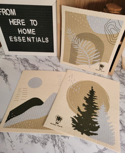 Three reusable, machine washable swedish dishcloths in Forest theme on a table.