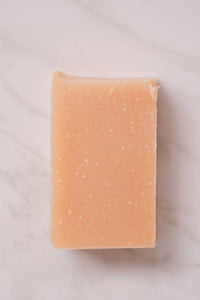 A close up of a single bar of peach colored, vegan, no-waste Citrus sunshine soap from NoToxLife