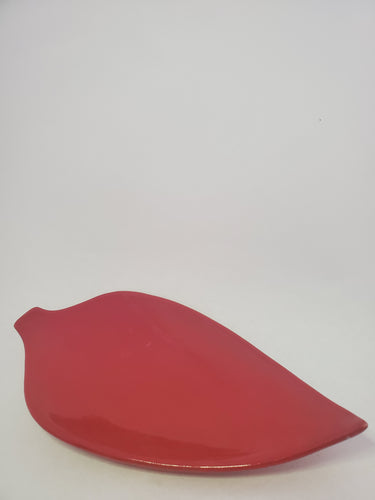 A red, high-gloss leaf shaped plate handmade in Cambodia.
