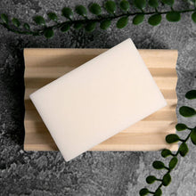 Load image into Gallery viewer, A white conditioner bar rests on a wooden soap holder.
